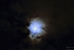 Earthshine on moon behind clouds